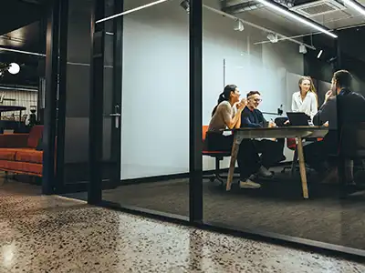 A business meeting in a nicely appointed conference room with video and display capabilities.