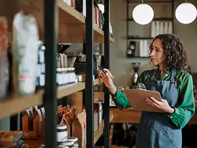 A small business owner takes inventory using an Internet-connected device.